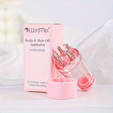 Pink scalp and hair oil applicator with packaging on a white background